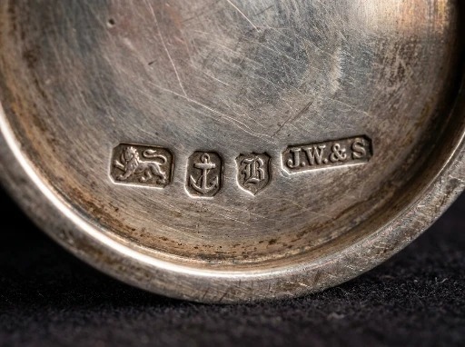 Close-up of the hallmarks struck on the base of an antique silver tea service