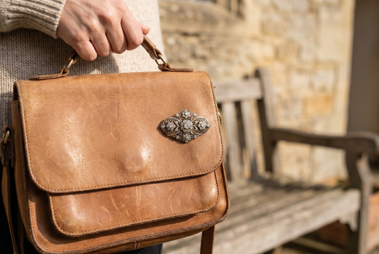 An antique diamond brooch pinned to a leather handbag