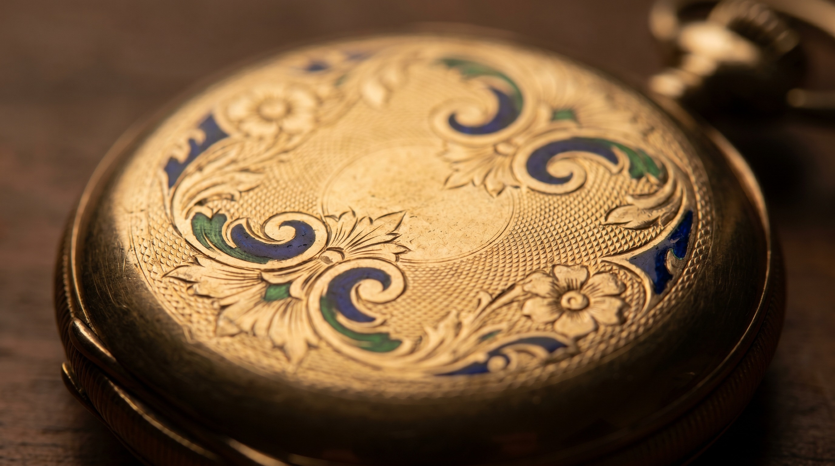 Ornately engraved and enamelled gold case-back of an antique fob watch