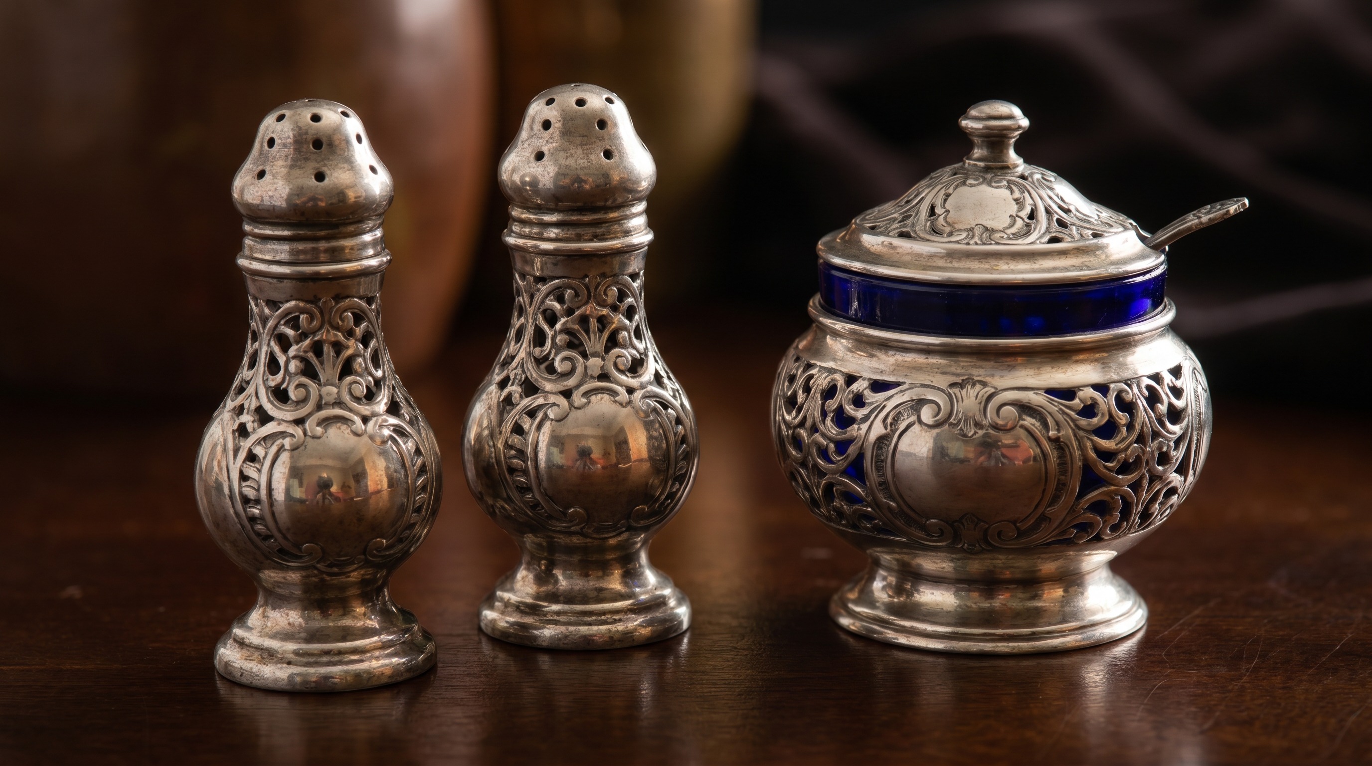Pierced antique silver casters and a mustard pot with blue glass liner