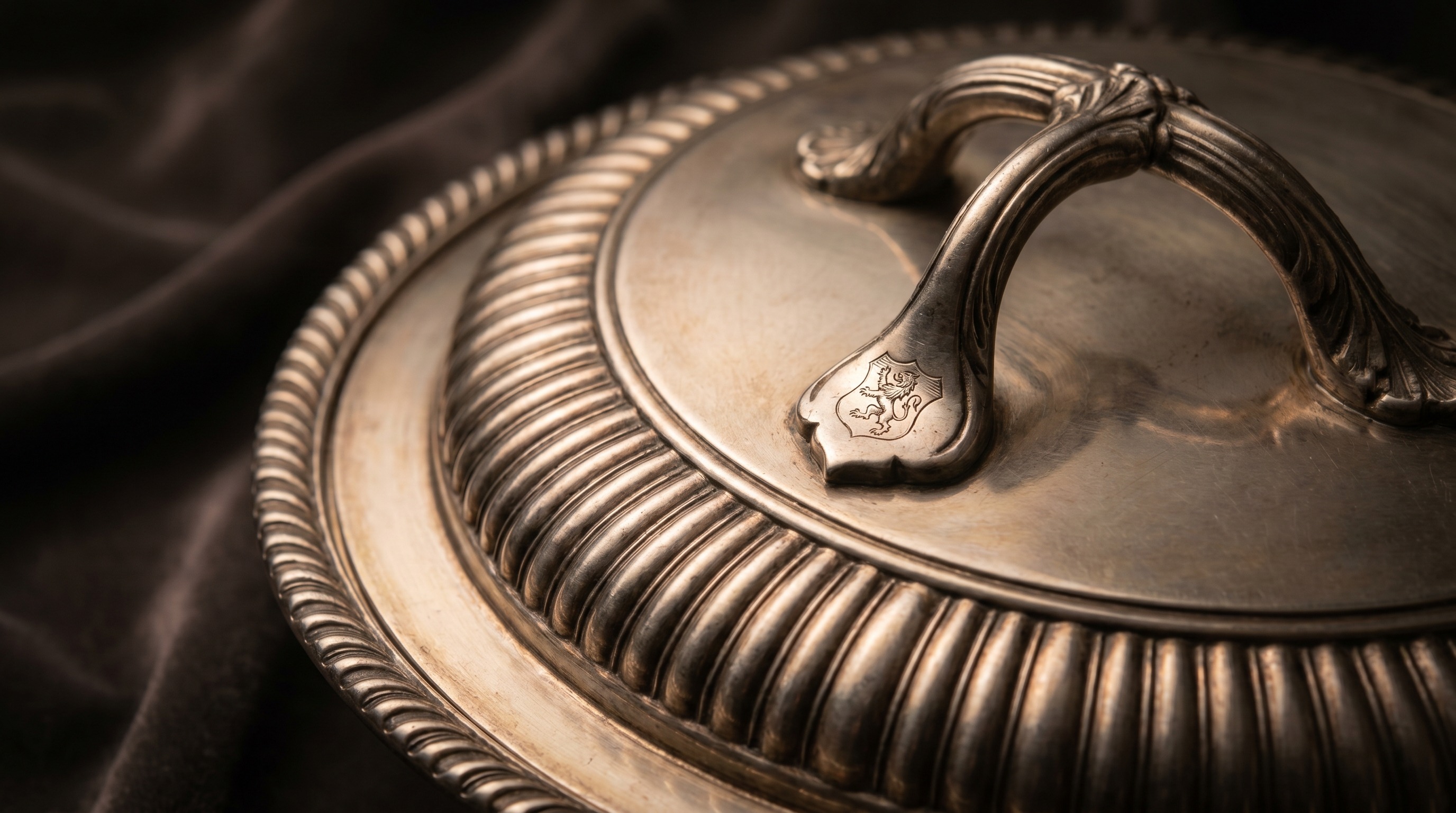 Detachable handle and gadrooned rim of an antique silver entrée dish cover
