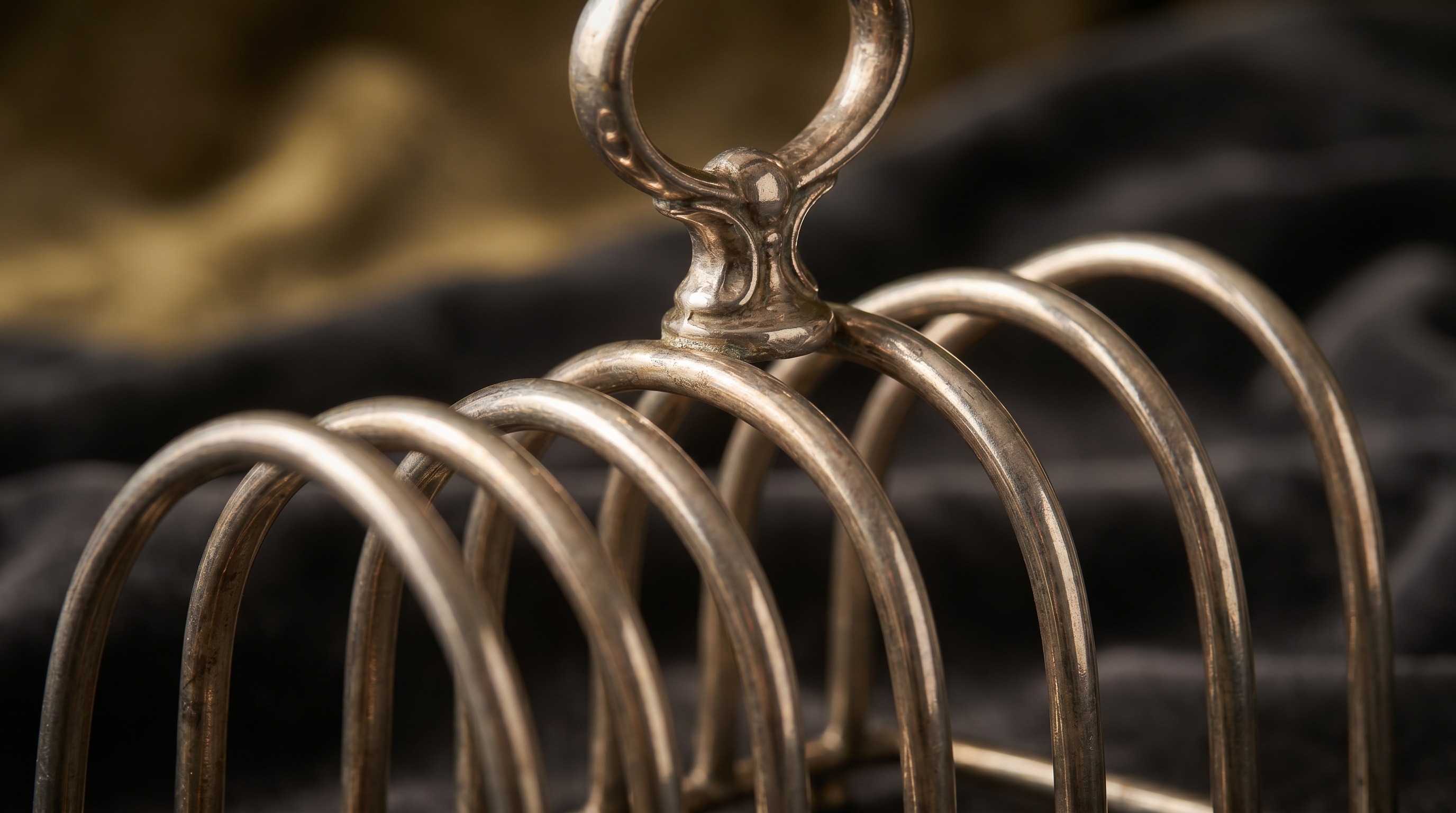 Close-up of the arched bars of an antique silver toast rack