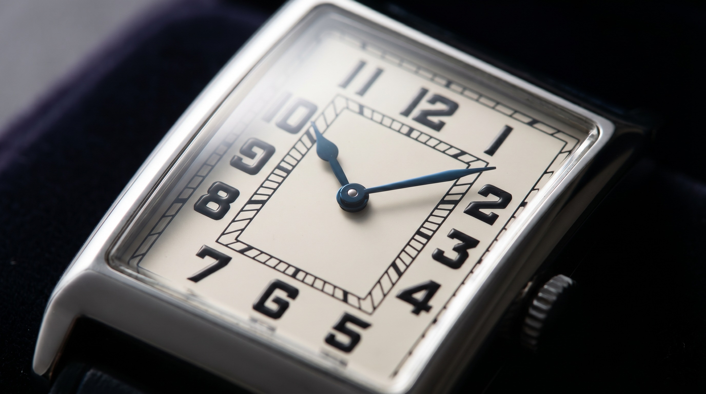 Macro of an Art Deco watch dial with bold geometric Arabic numerals and blued steel hands
