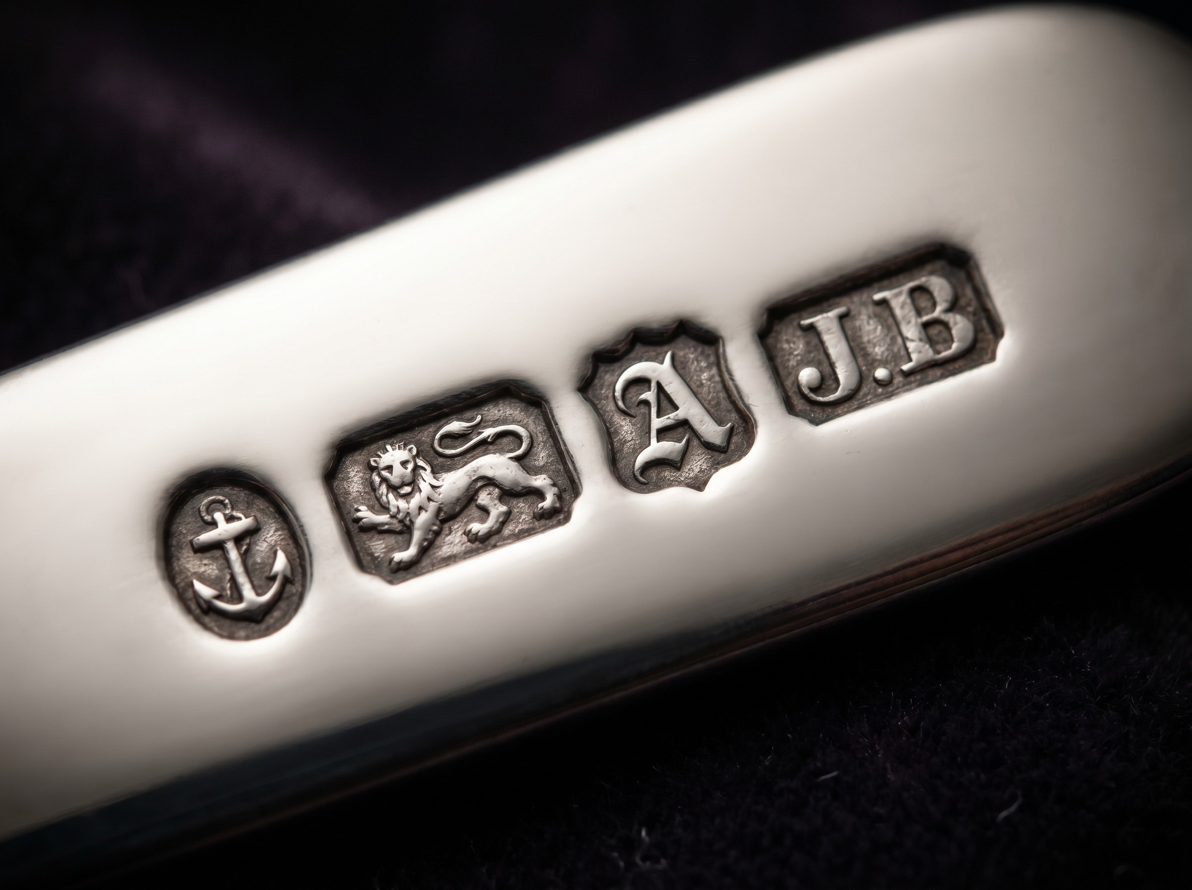 Full row of Birmingham hallmarks struck on antique sterling silver — anchor, lion passant, date letter and maker's mark