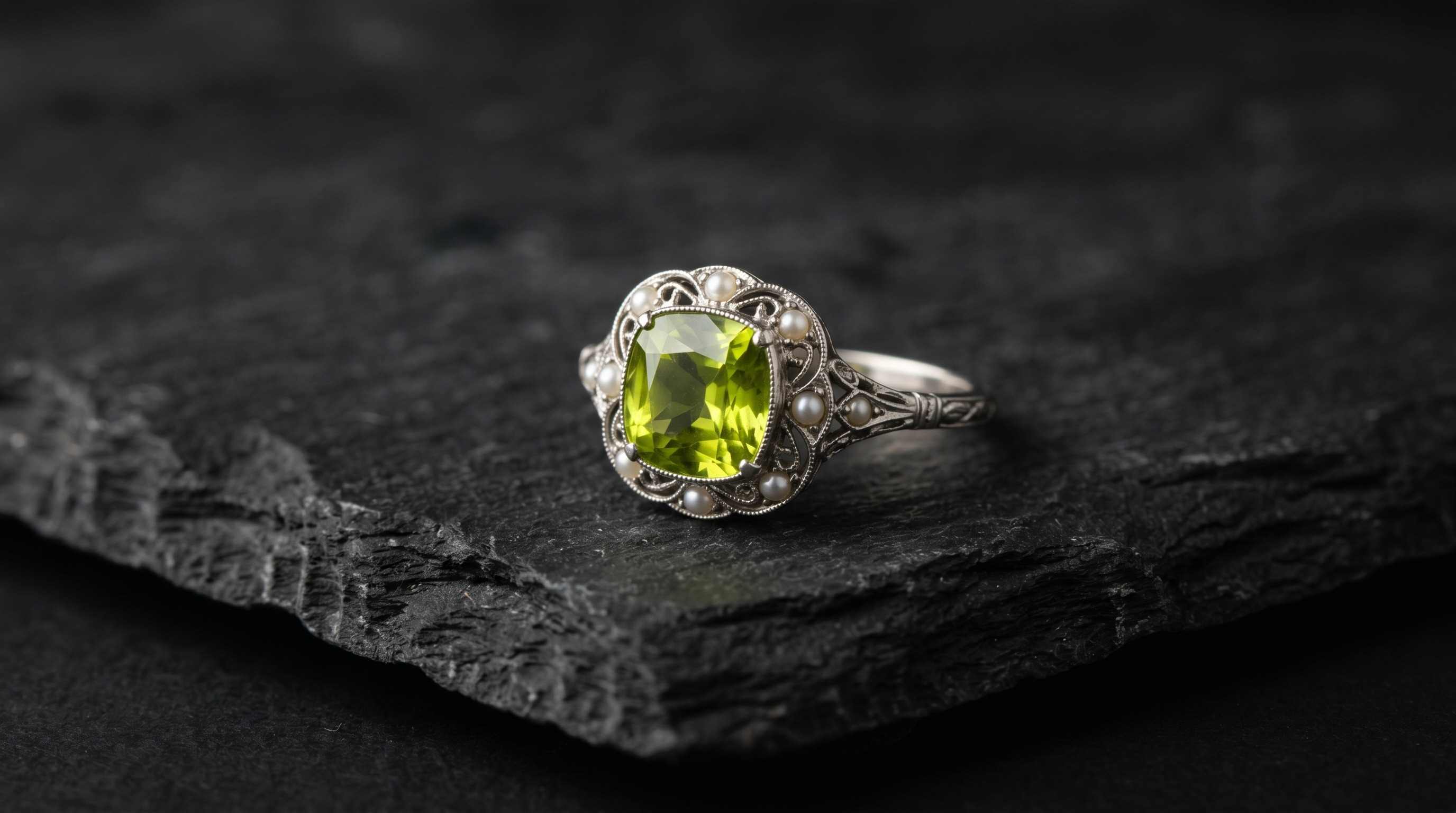 Antique peridot and seed-pearl ring, the August birthstone, on a dark editorial background