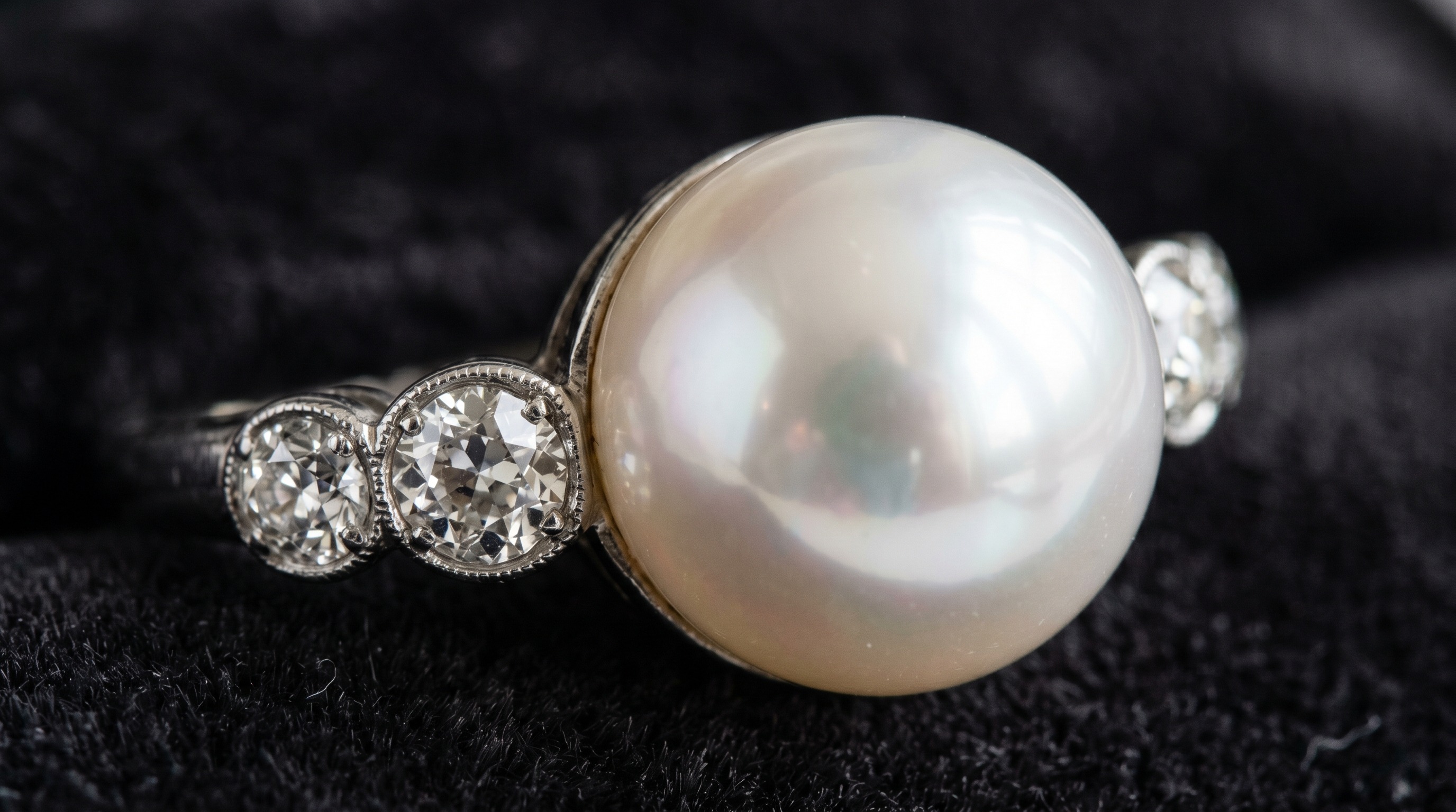Macro of a lustrous white pearl with soft orient, set with old-cut diamonds in an antique mount