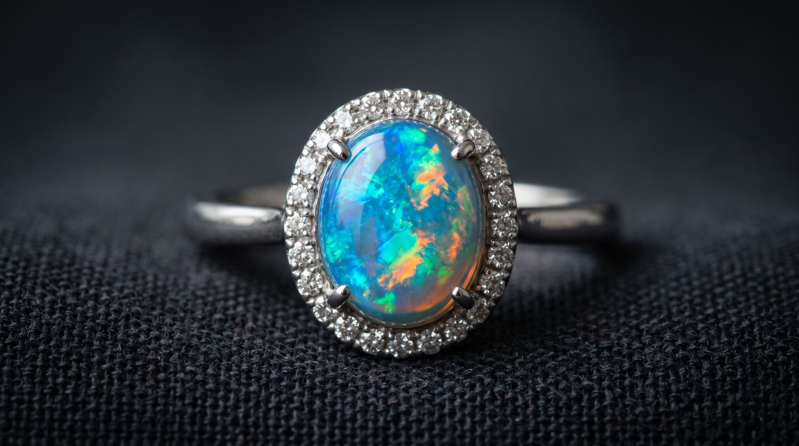 Macro of an opal cabochon showing vivid play-of-colour, set with diamonds in an antique mount