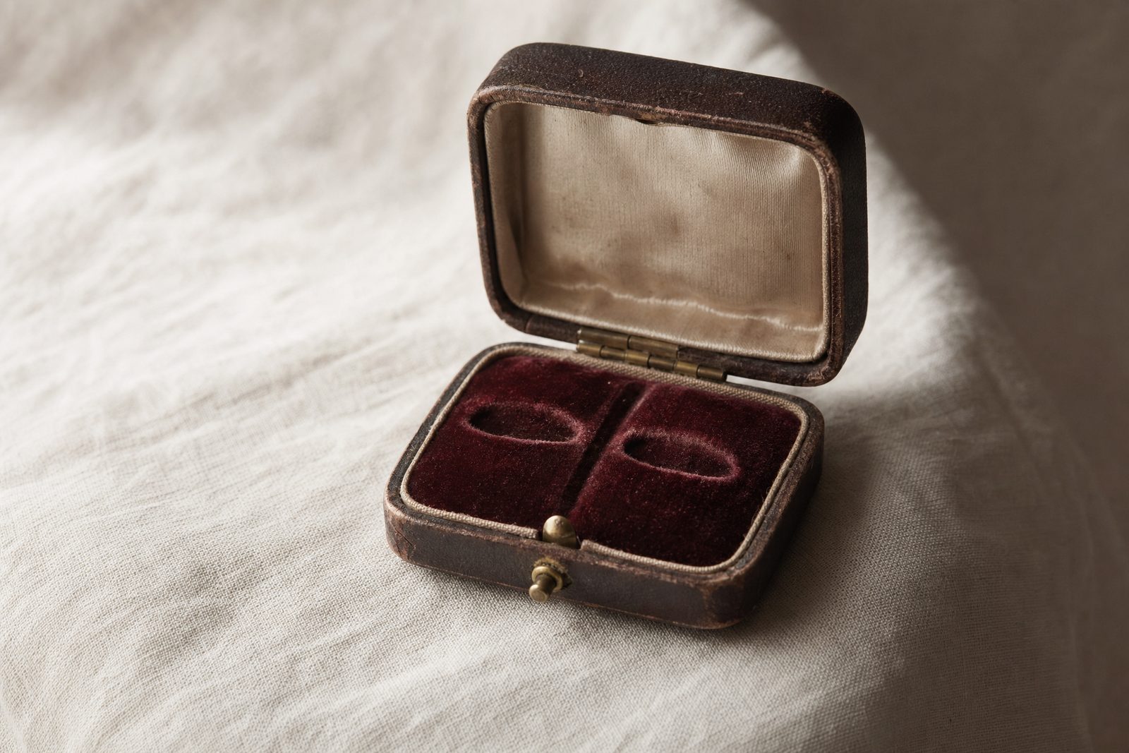 Antique twin-slot velvet ring box, open and empty, with impressions where two rings once sat side by side