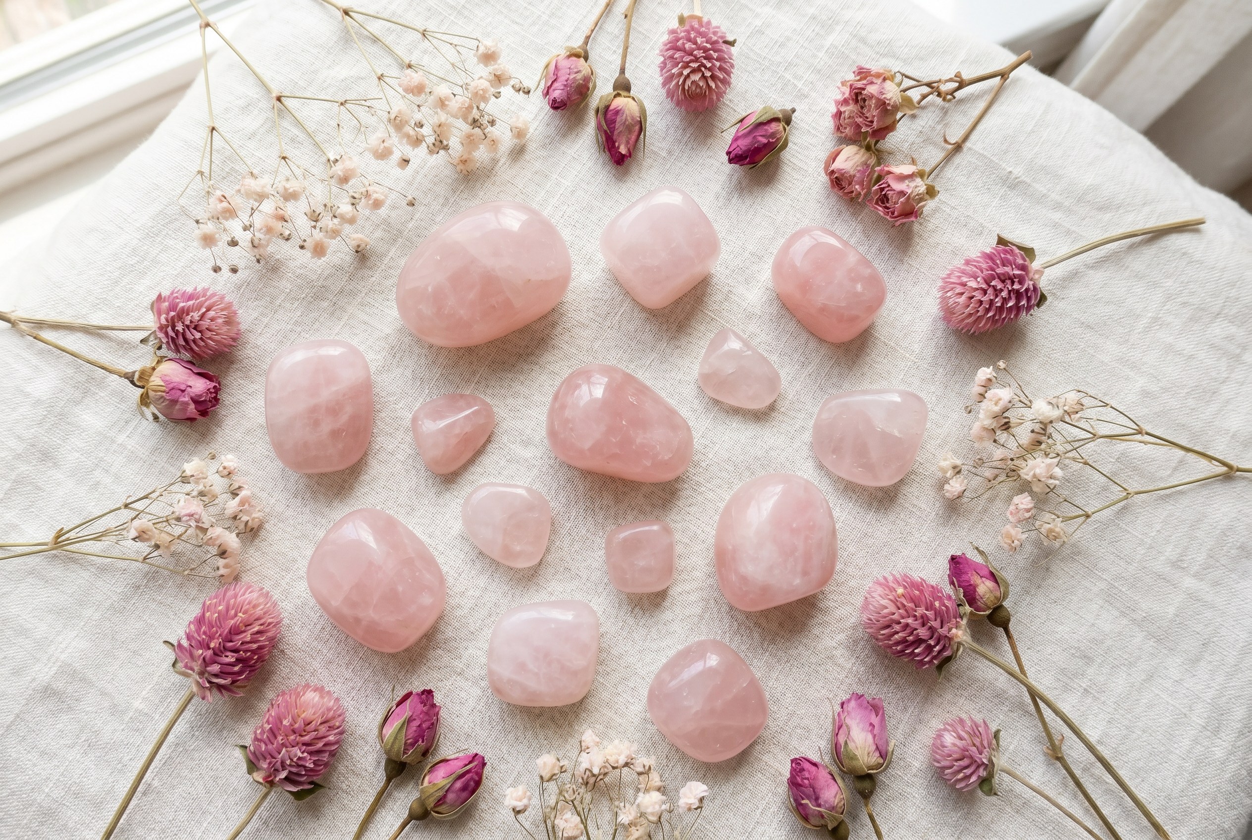 Rose quartz tumbled stones with dried pink flowers