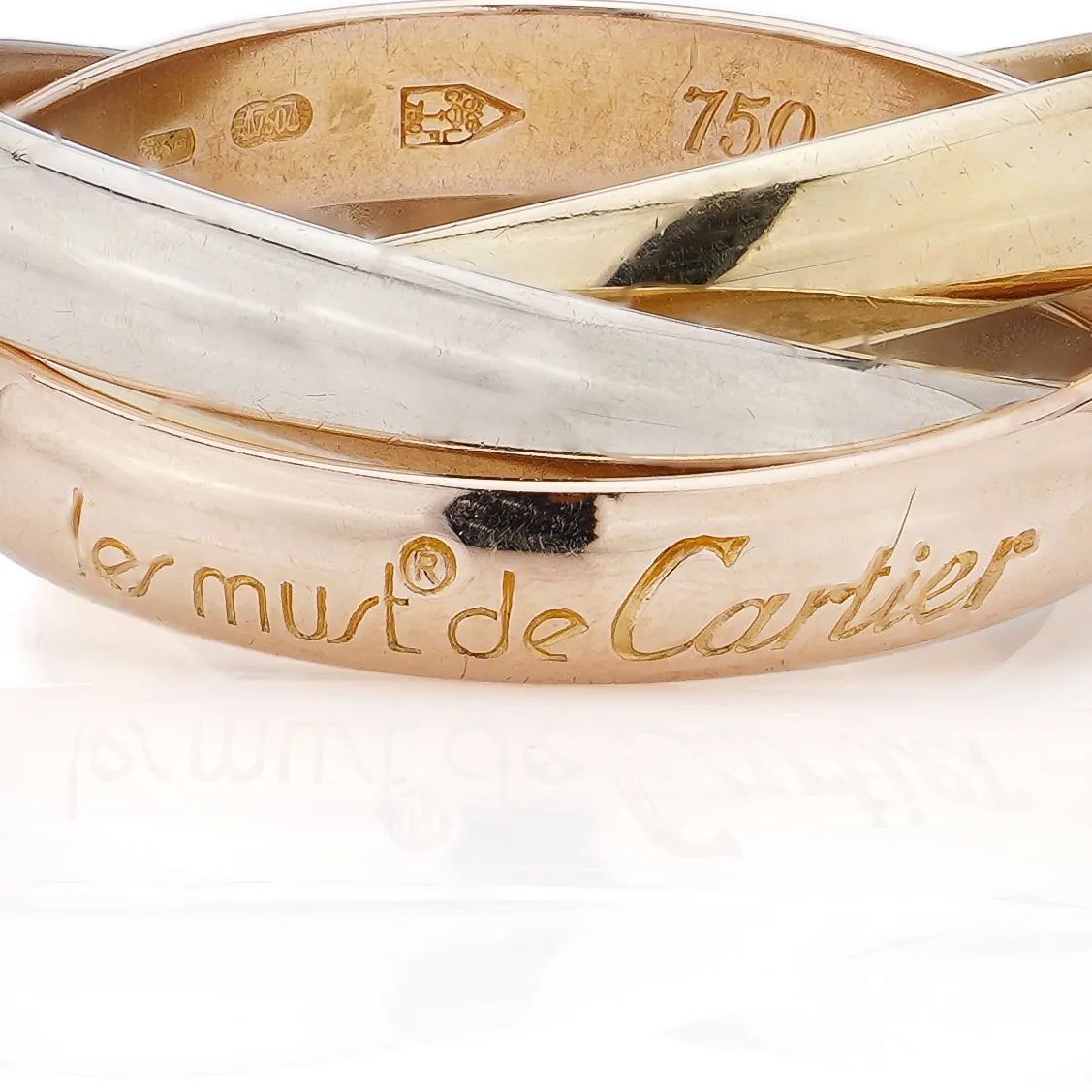 Les must de Cartier signature and 750 gold mark engraved inside a Cartier Trinity ring