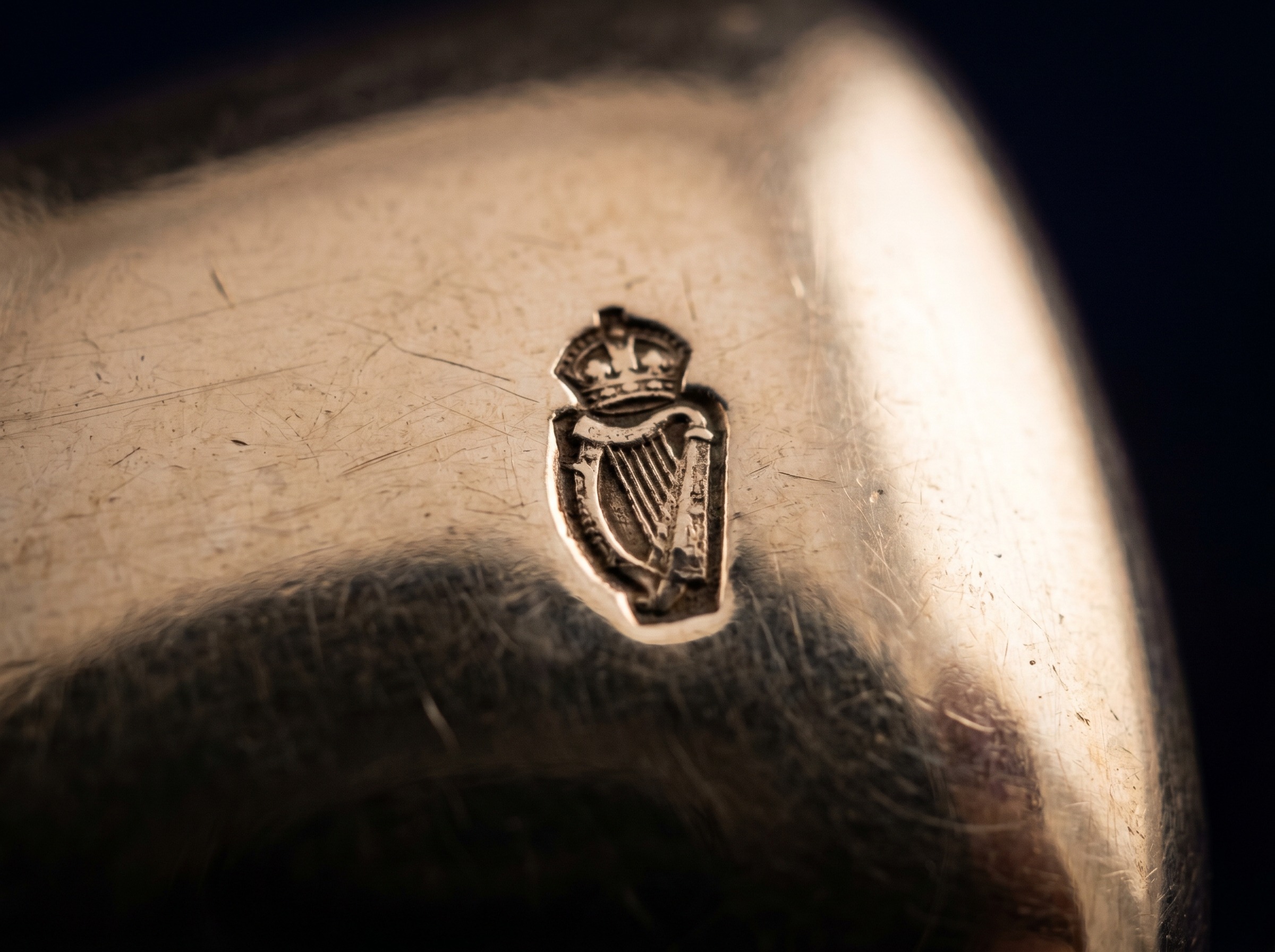 Extreme macro of crowned harp sterling standard hallmark struck on antique Irish silver