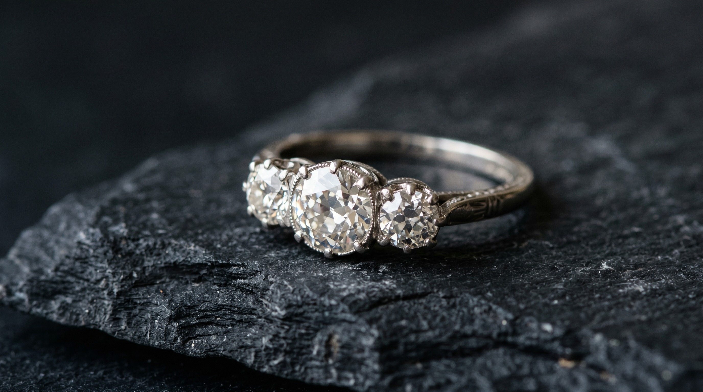 Antique three-stone diamond engagement ring on a dark background