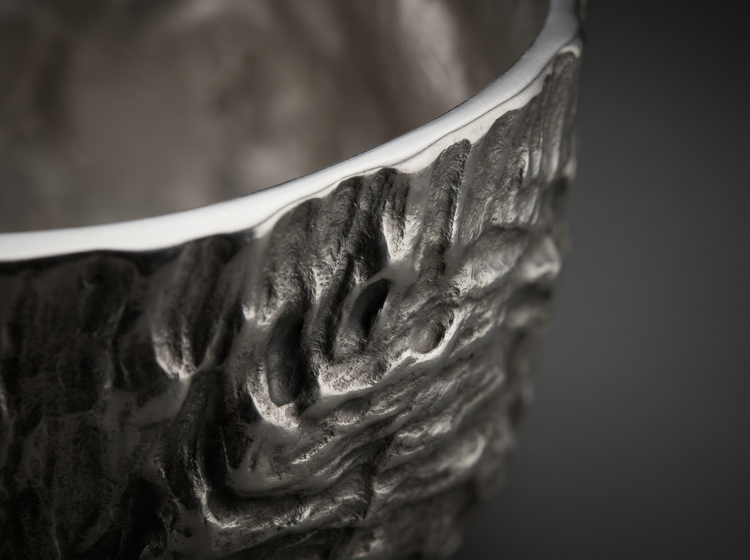 Deeply worked organic bark texture on modern sterling silver in the Gerald Benney style — macro