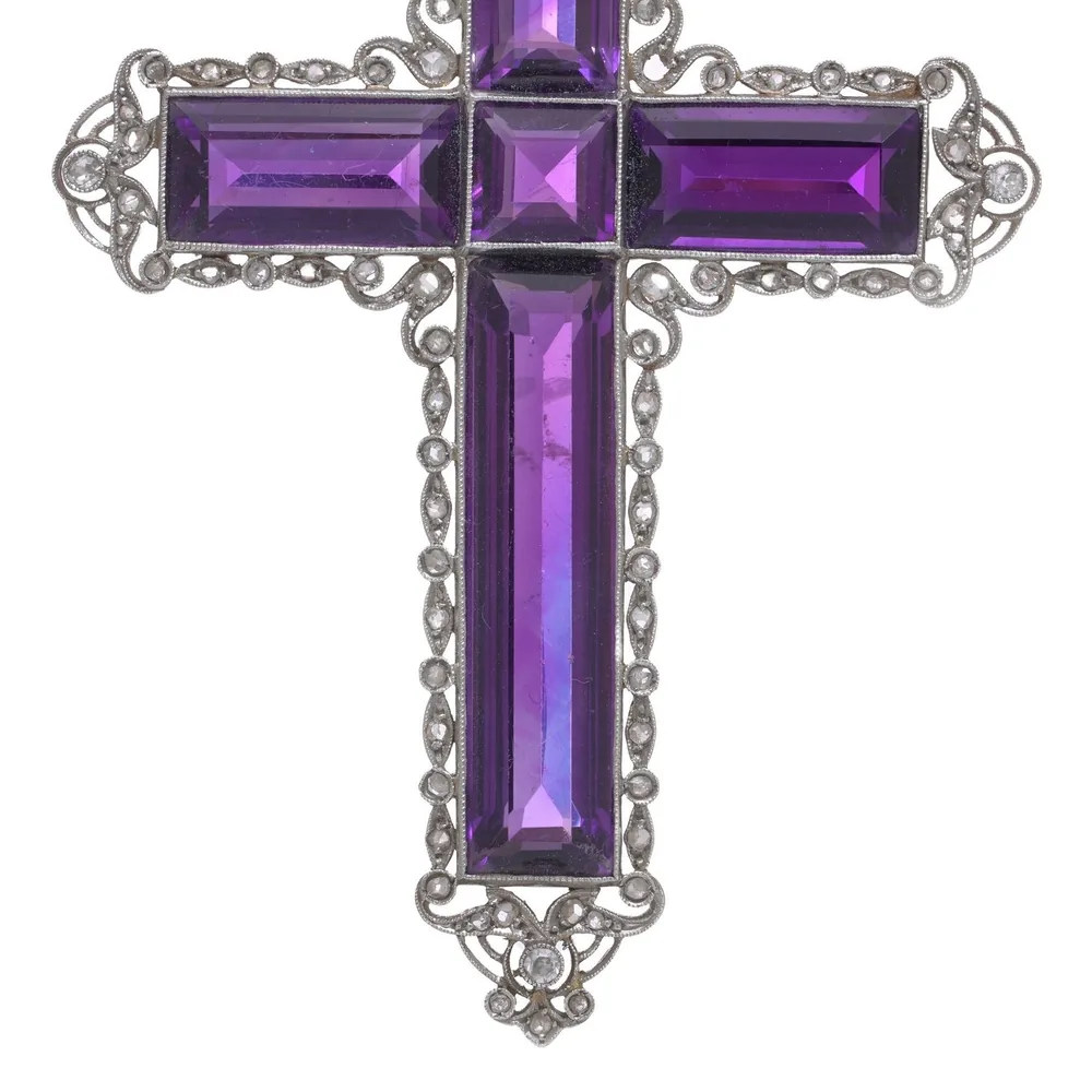 An Edwardian cross pendant set with deep purple step-cut amethysts in a gold and silver frame with small diamonds