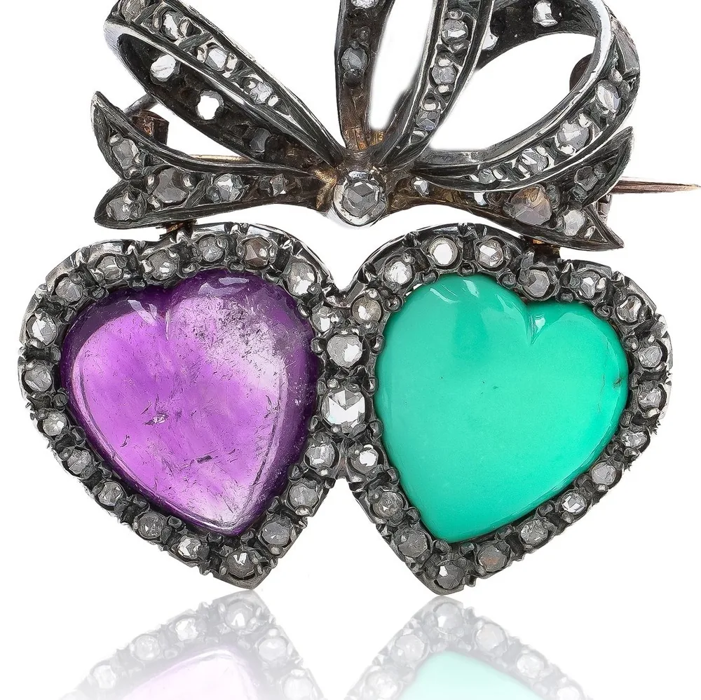 A Victorian double heart brooch: a heart-shaped amethyst and a turquoise heart in rose diamond frames under a diamond bow