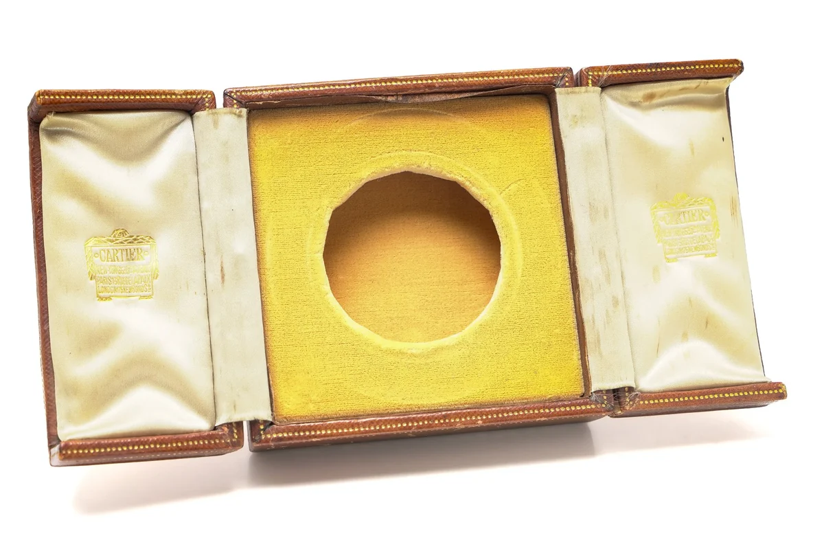 Antique Cartier leather presentation case for a small clock or medallion, opened to show the silk lining and the round velvet recess
