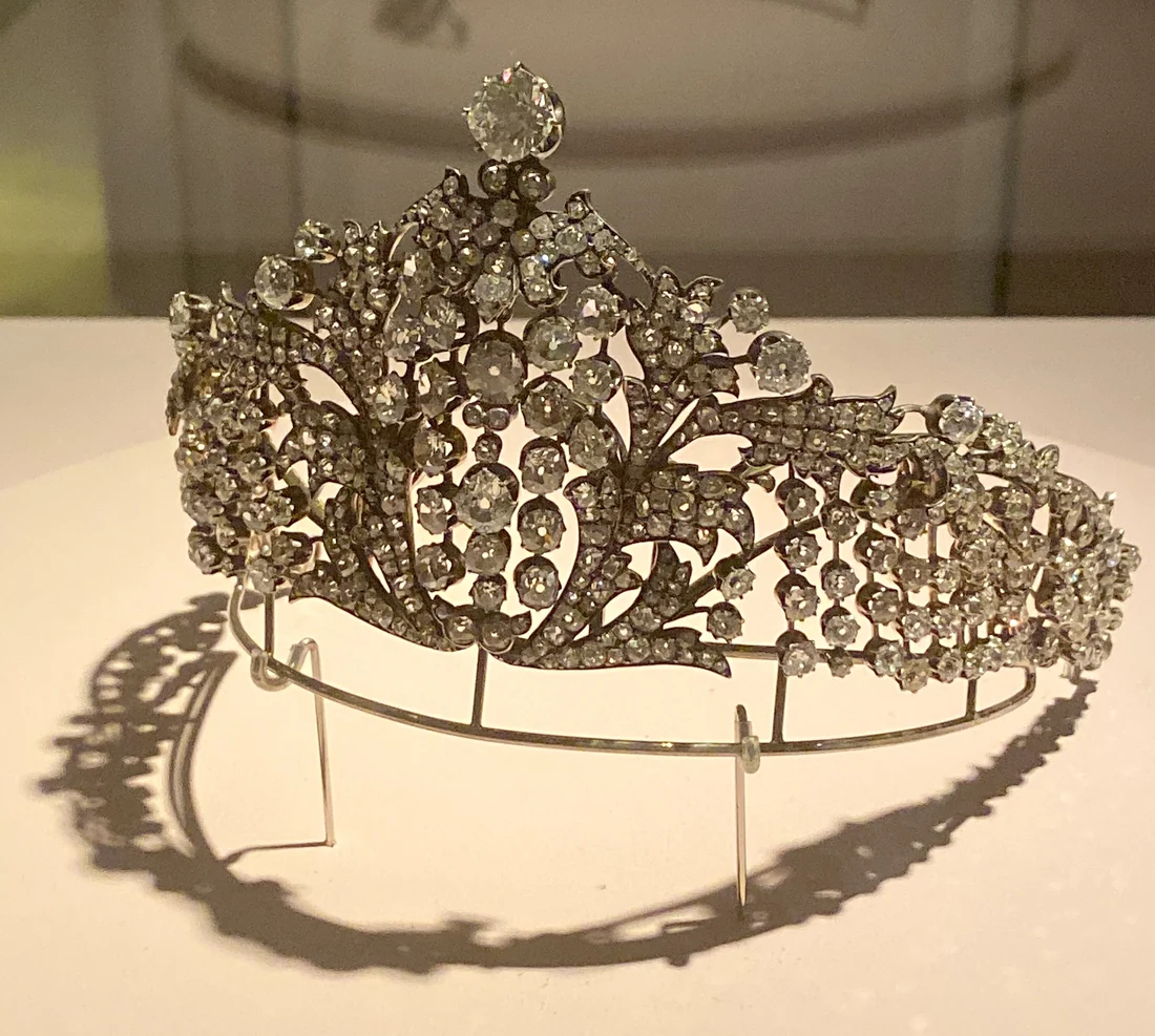 A diamond tiara of about 1885 by Michael Perkhin, the Faberge workmaster, set in silver: tall scrolling diamond sprays rising to a large diamond at the top, on a wire display stand