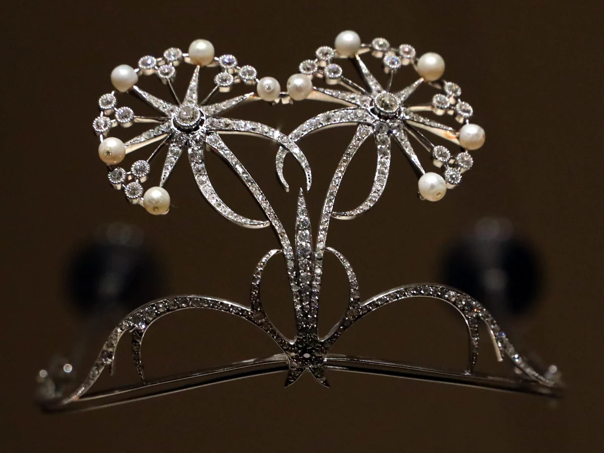 A platinum, diamond and pearl tiara by Henri Vever, France, about 1900: two stylised diamond flower heads tipped with pearls on curving diamond stems