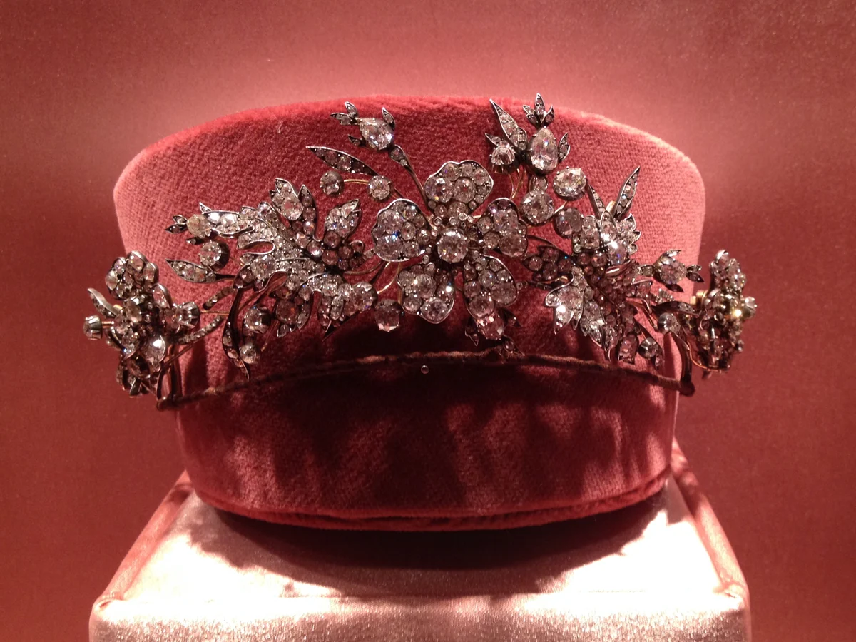 A diamond floral spray tiara of about 1855 by A. E. Koechert of Vienna, set in silver on gold, displayed on a red velvet stand