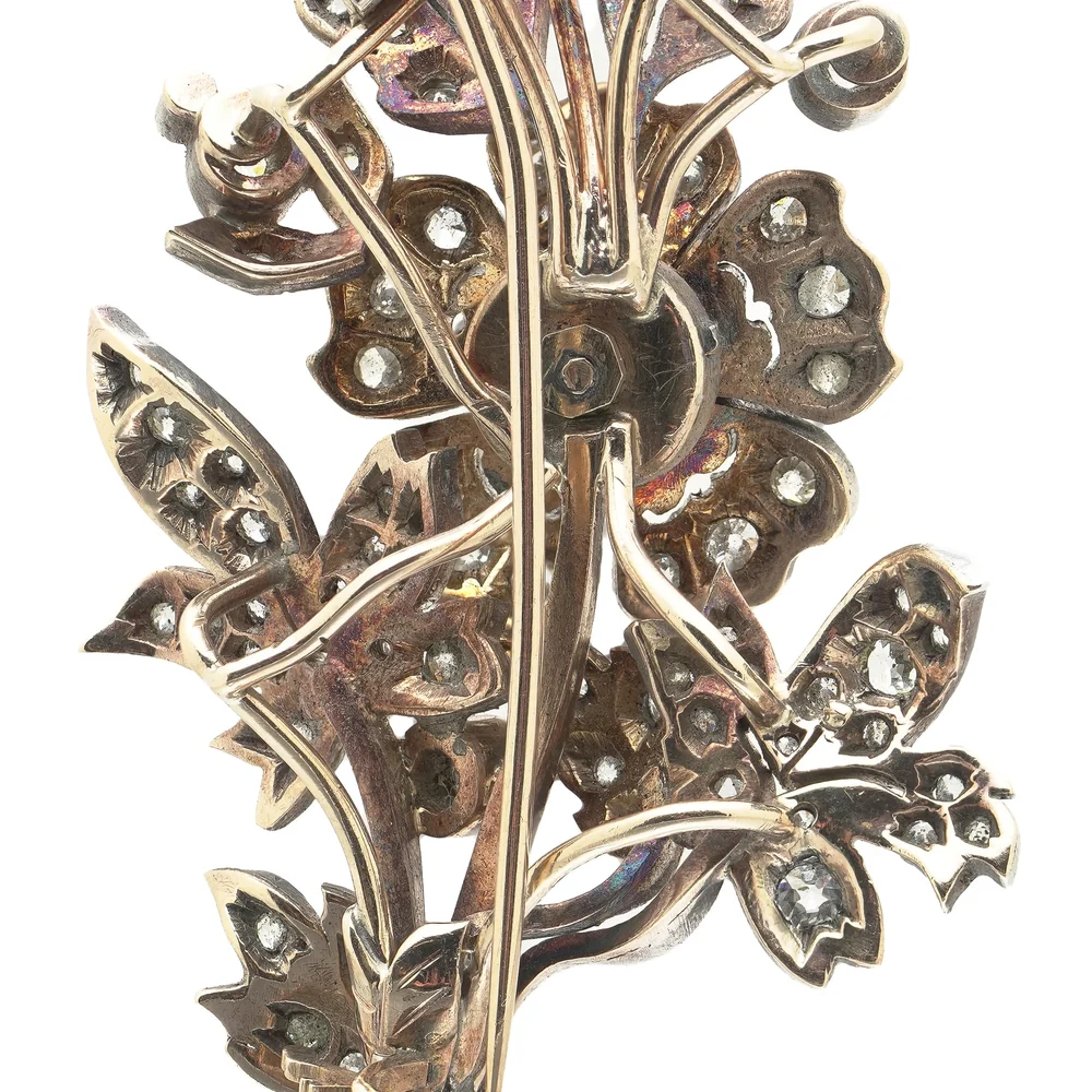 The back of a Victorian diamond flower spray: the yellow gold reverse of the mount, with the diamonds set in silver on the front