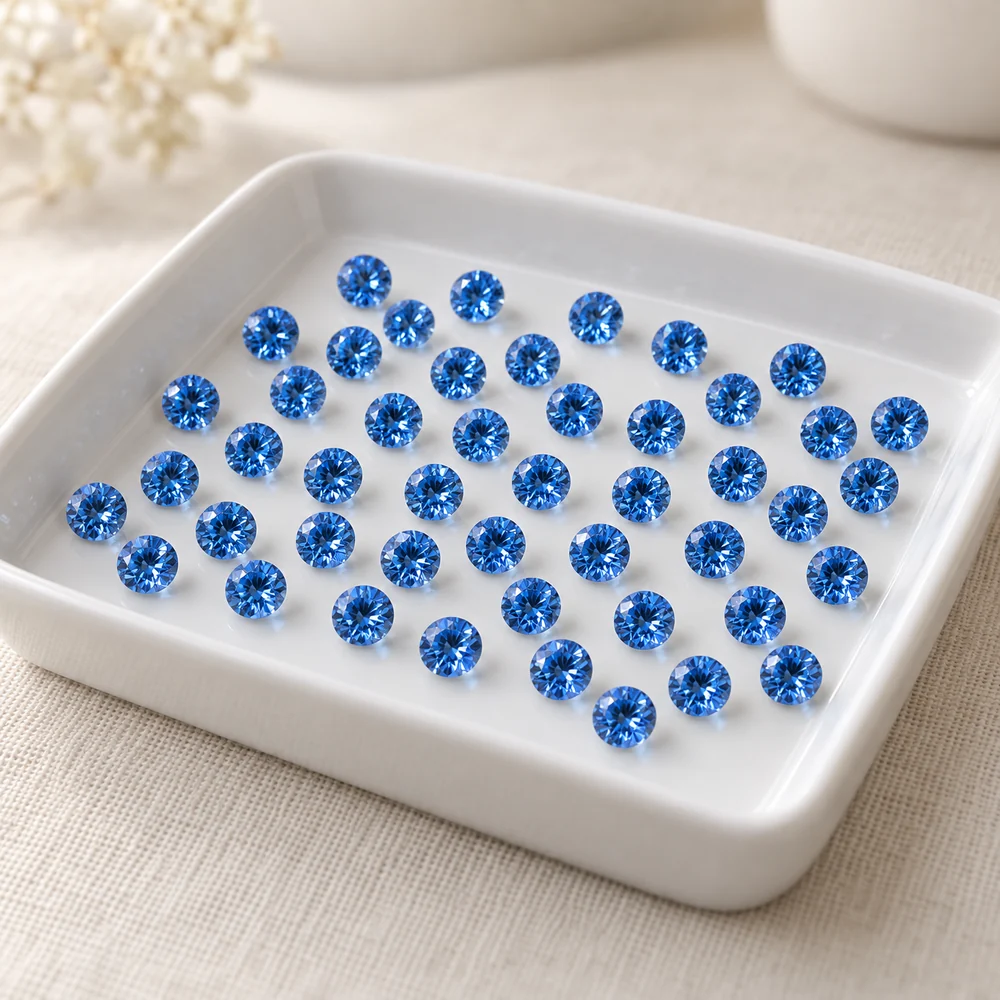 Illustration of many identical bright blue round diamonds in a white sorting tray