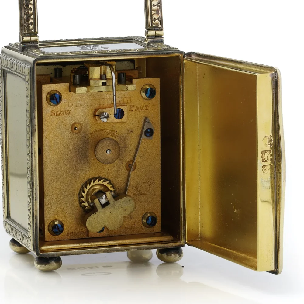 Carriage clock back door open on a gilt movement backplate marked Slow and Fast, with a lion trademark and French Made stamp