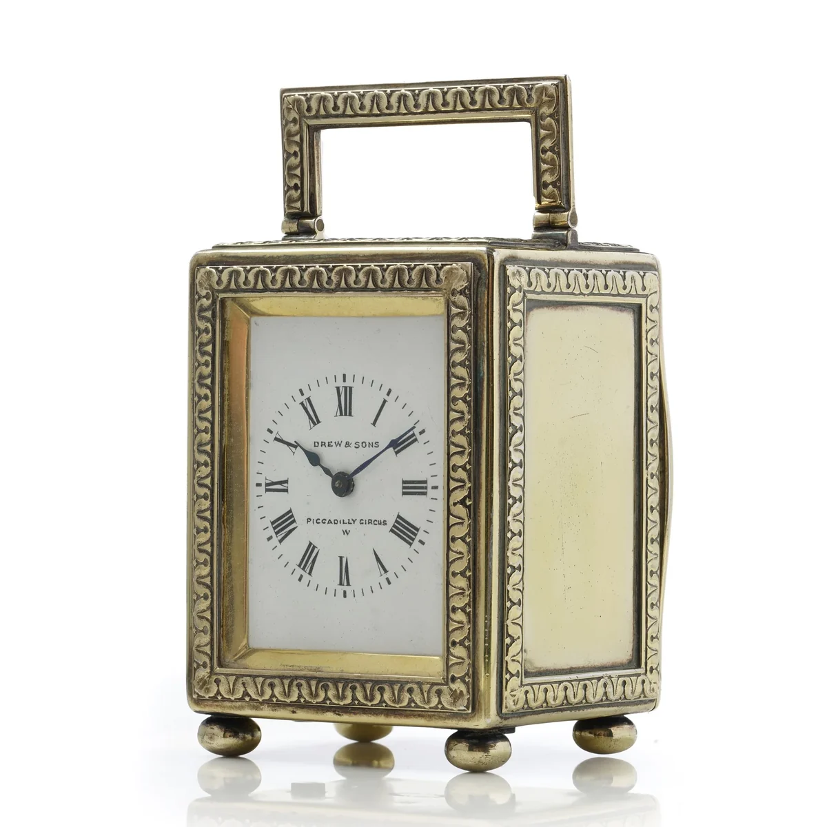 Edwardian silver-gilt miniature carriage clock by Drew and Sons, London 1913, with white enamel dial, embossed foliate borders and bun feet