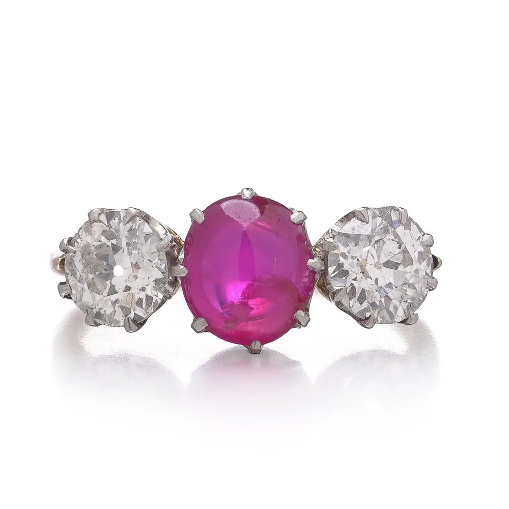 Antique three stone ring with a cabochon ruby between two old European cut diamonds