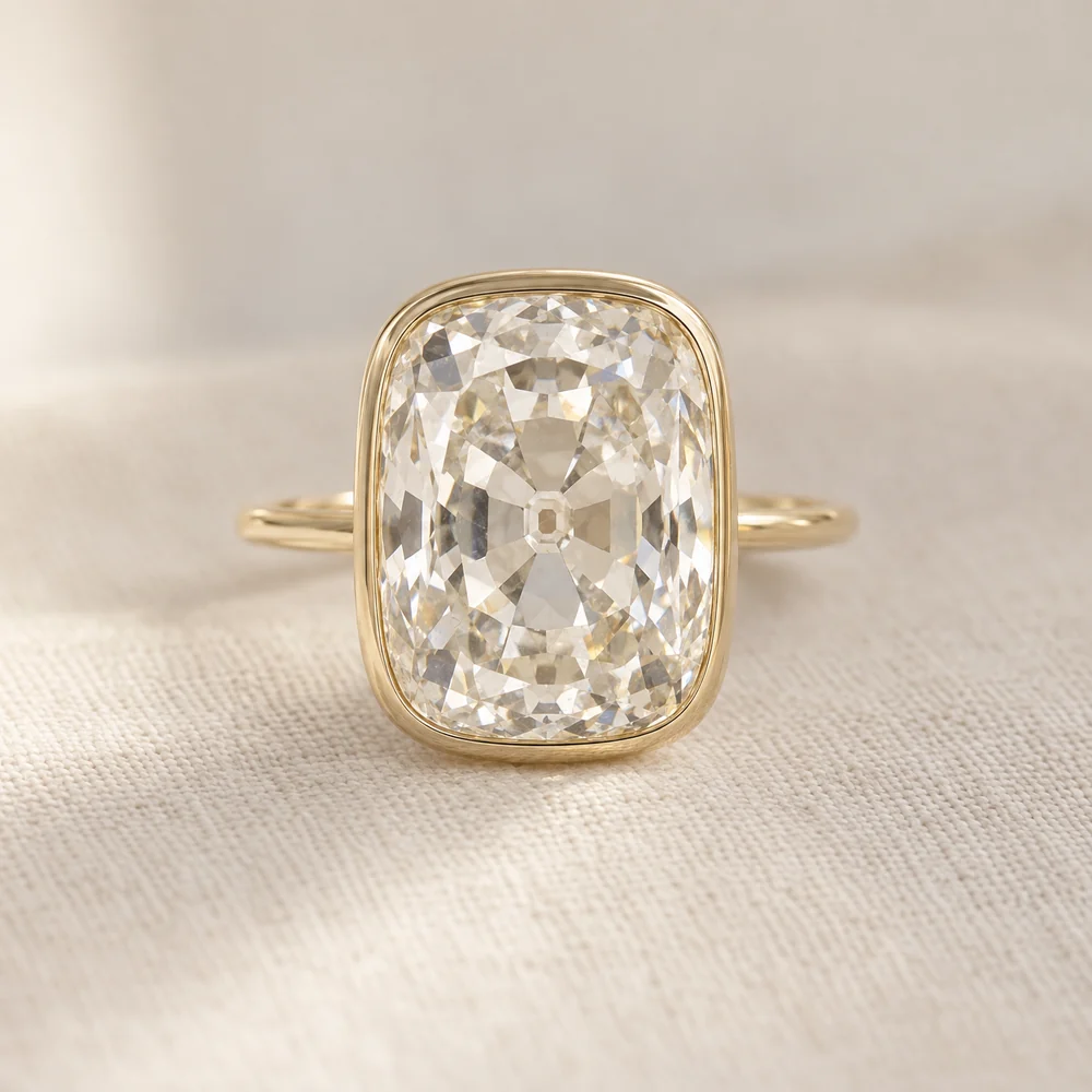 Illustration of an elongated antique cushion cut diamond in a polished yellow gold bezel on a thin yellow gold band