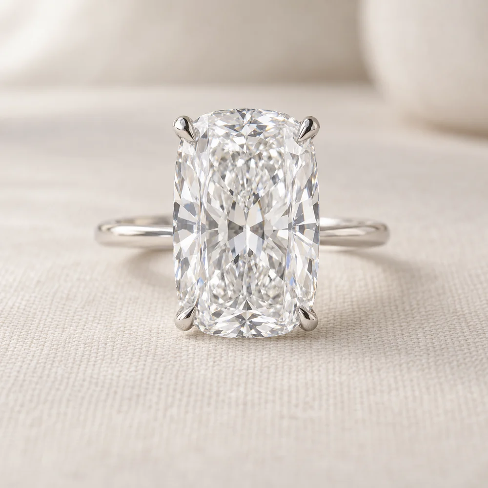 Illustration of an elongated cushion cut diamond solitaire in four slim platinum claws on a thin band