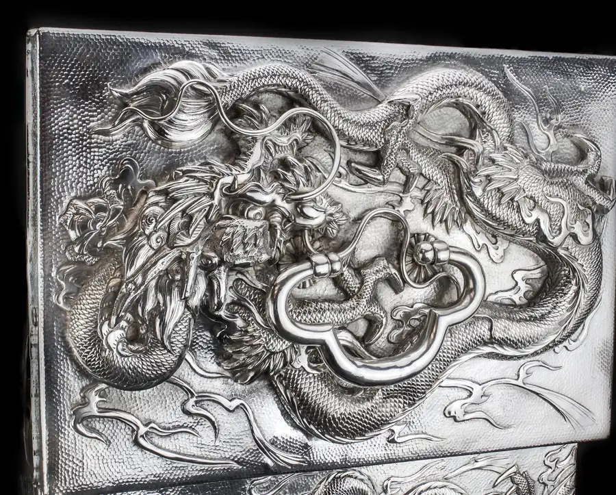 Lid of a Chinese export silver box chased with two dragons around the loop handle
