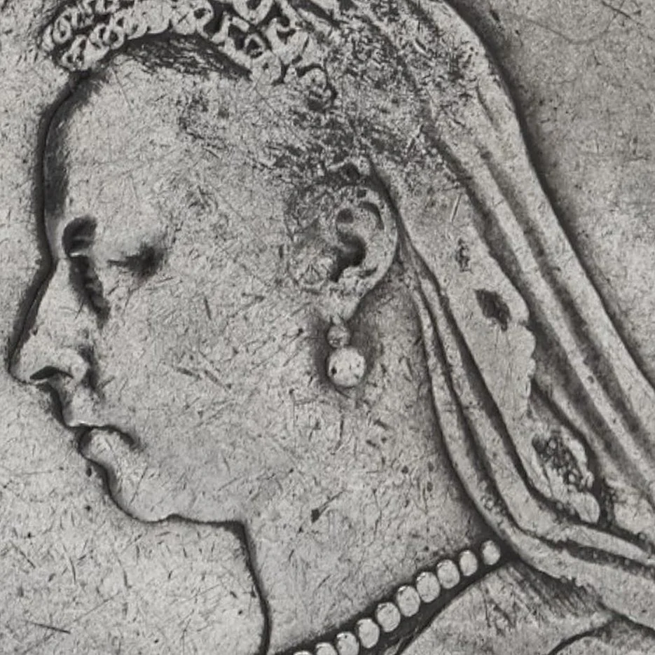 Close-up of Queen Victoria's portrait on an 1889 silver crown, showing wear and fine scratches on the highest points