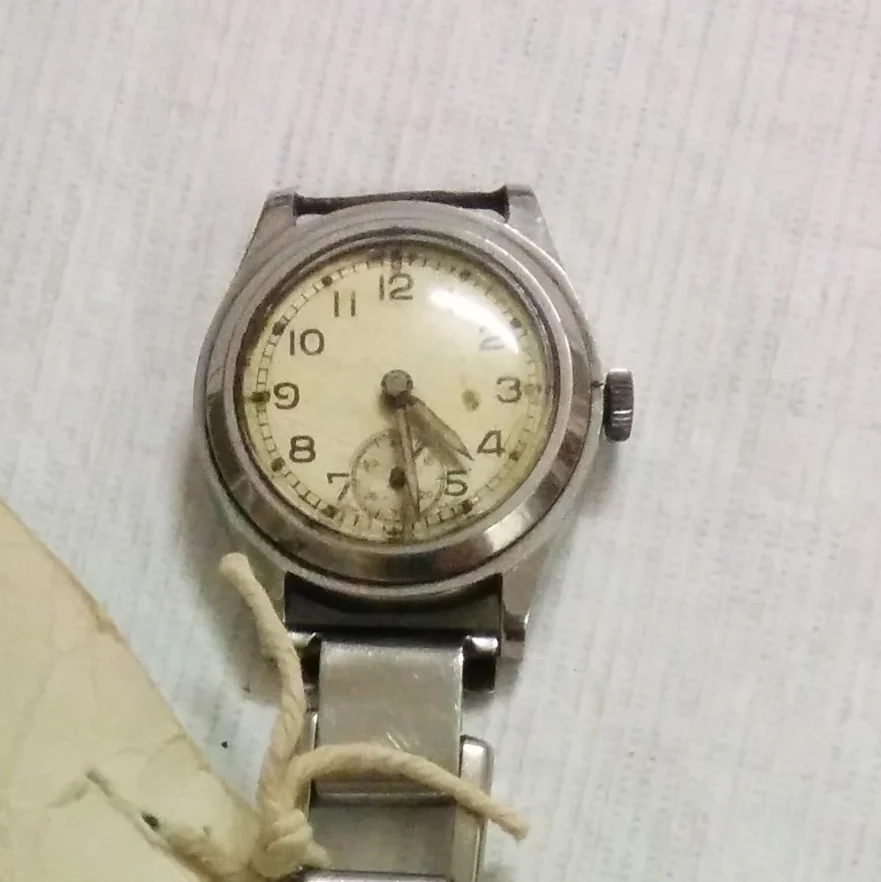 A Second World War A.T.P. (Army Trade Pattern) wristwatch with a cream dial, Arabic numerals and small seconds, in the Auckland War Memorial Museum