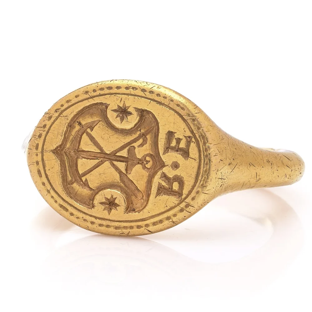A 17th century gold signet ring, the oval bezel engraved with an anchor, shipwright's tools, two stars and initials