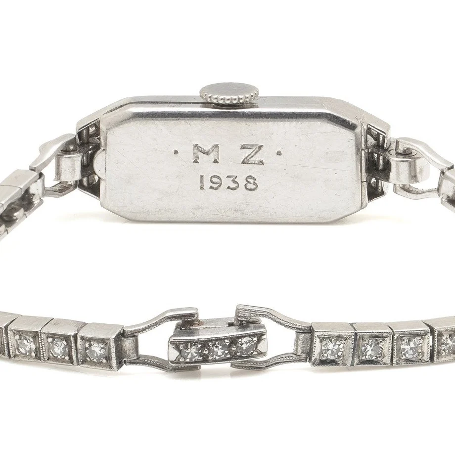 The platinum case back of a Tiffany & Co. Art Deco cocktail watch engraved M.Z. 1938, on its diamond-set bracelet