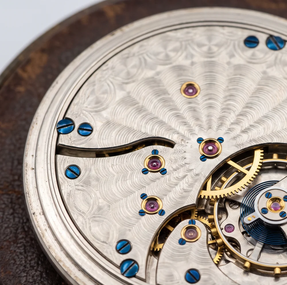 Damaskeened nickel pocket watch movement with ruby jewels in gold settings and blued screws