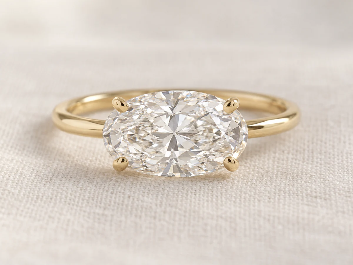 Illustration of an oval diamond set east-west, lying across a slender yellow gold band