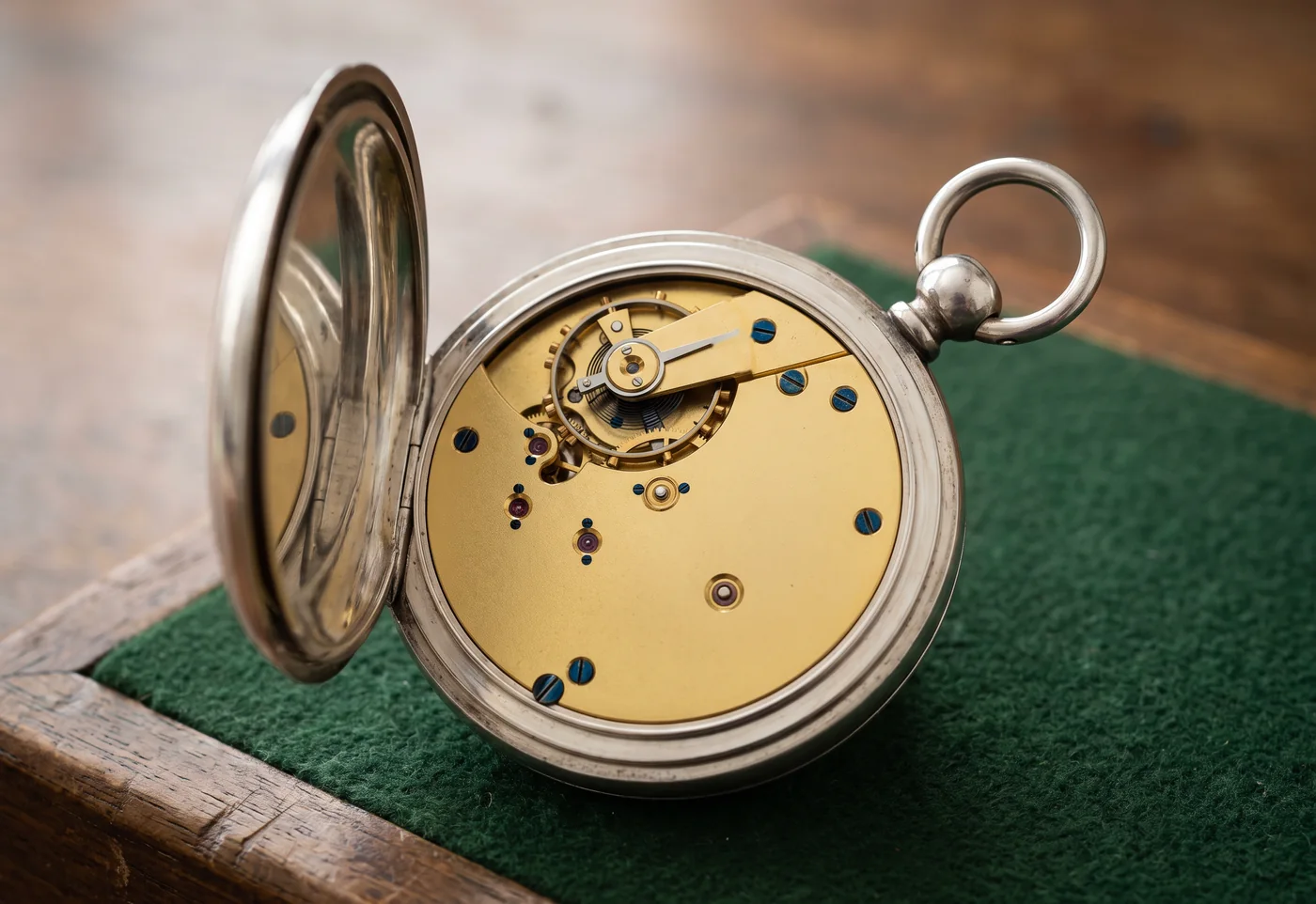 Victorian English silver key wind pocket watch with the case back open, showing a gilt full plate English lever movement with blued screws and a cut bimetallic balance