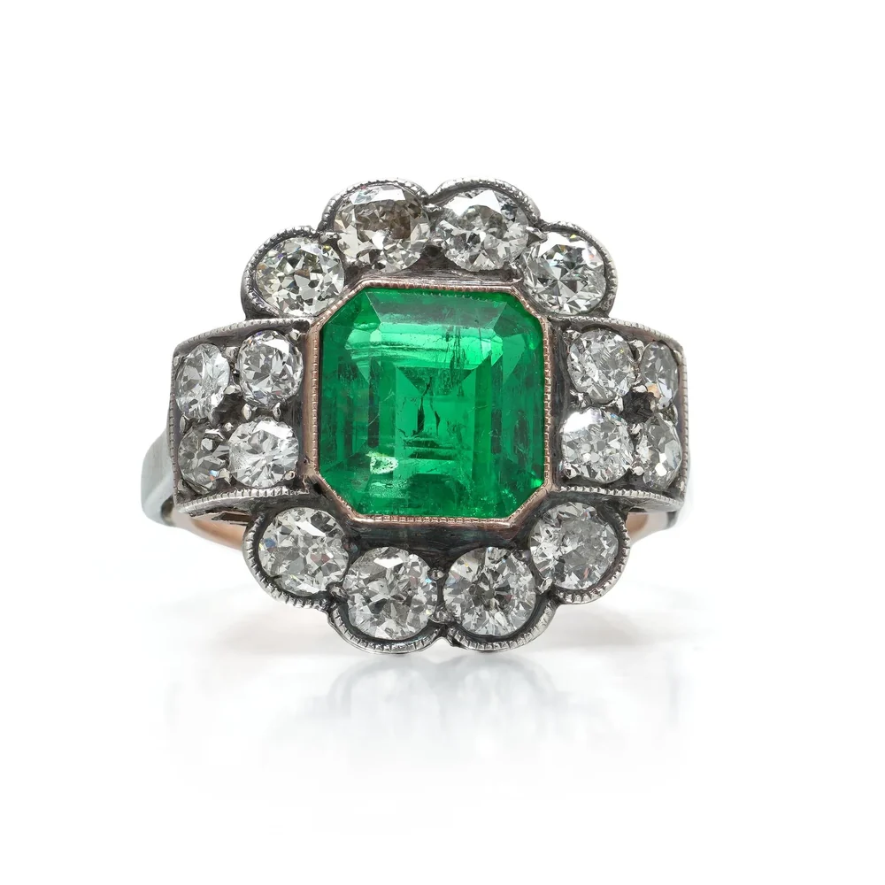 A Victorian emerald and old cut diamond cluster ring from our collection, photographed front on against a plain white background