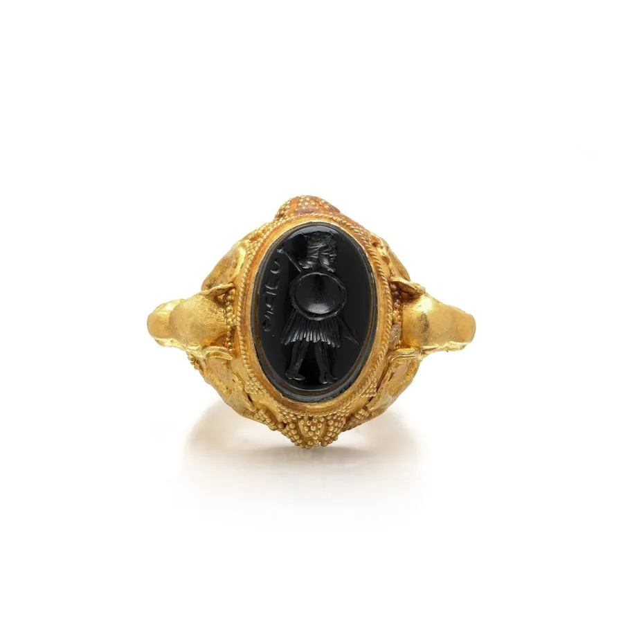 Archaeological revival high carat gold ring with an onyx intaglio and lion head shoulders