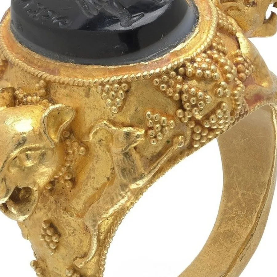 Close-up of gold granulation clusters and a twisted wire collet on an archaeological revival ring