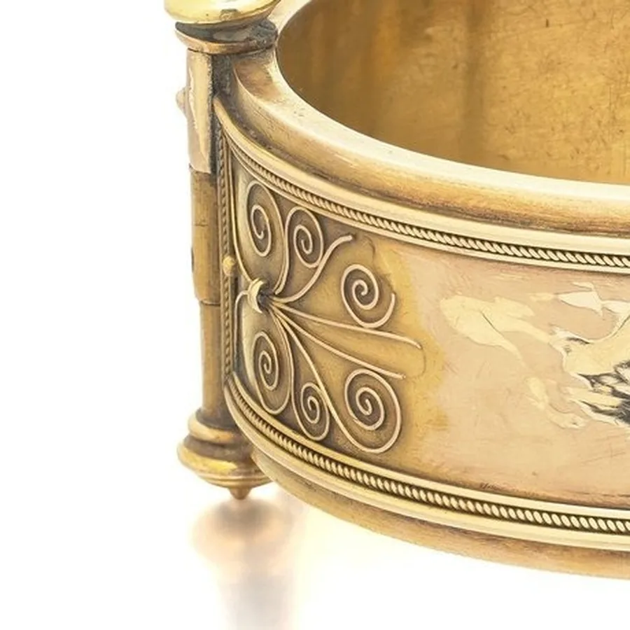 Gold wire scrolls soldered onto the reverse of a 19th-century bangle, framed by twisted wire borders