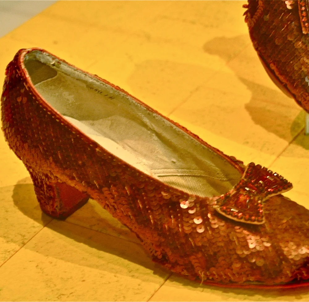 A red sequinned ruby slipper from The Wizard of Oz with a beaded bow, in its case at the Smithsonian's National Museum of American History