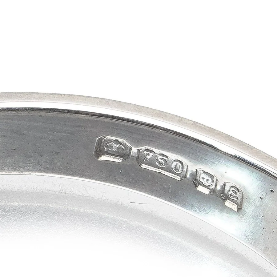 Inside an 18ct white gold half eternity ring: a crown, 750 in its shaped gold shield, an assay office mark and a date letter