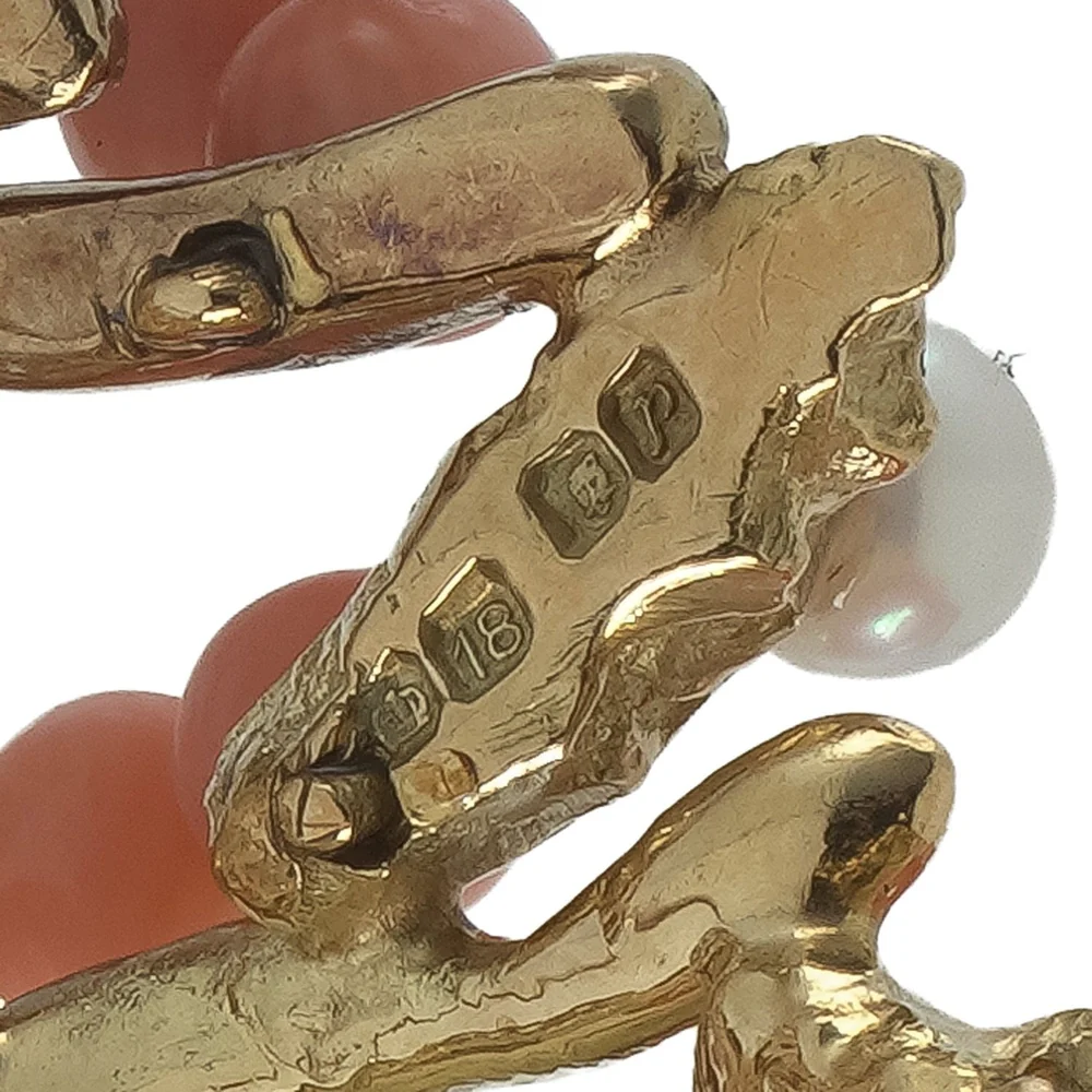 Old-style British hallmarks on the back of an 18ct gold brooch, with the figure 18 in a shield beside the other marks