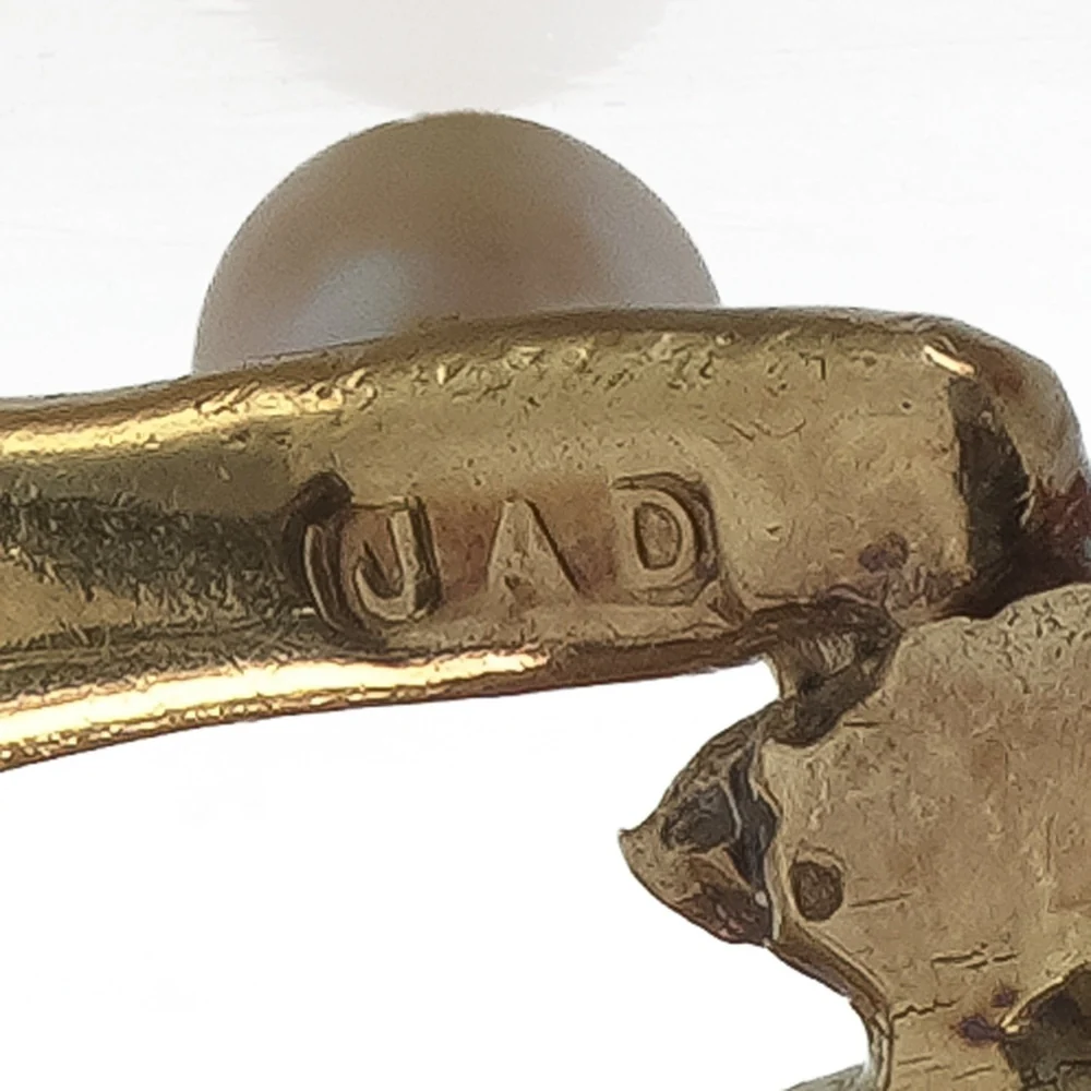 The JAD sponsor's mark of the goldsmith John Donald struck on the back of an 18ct gold brooch beside a pearl