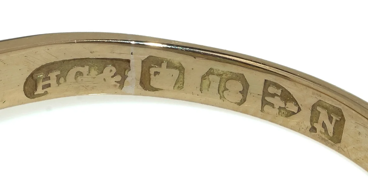 Hallmark inside an 18KT gold ring: sponsor's mark H.G.&S, crown, 18, the Chester town mark of three wheatsheaves and a sword, and the date letter for 1896
