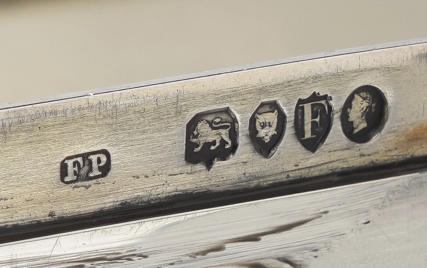 A full Victorian silver hallmark on a sandwich box rim: sponsor's mark FP, lion passant, leopard's head, date letter F in a shield and Queen Victoria's head duty mark, London 1881