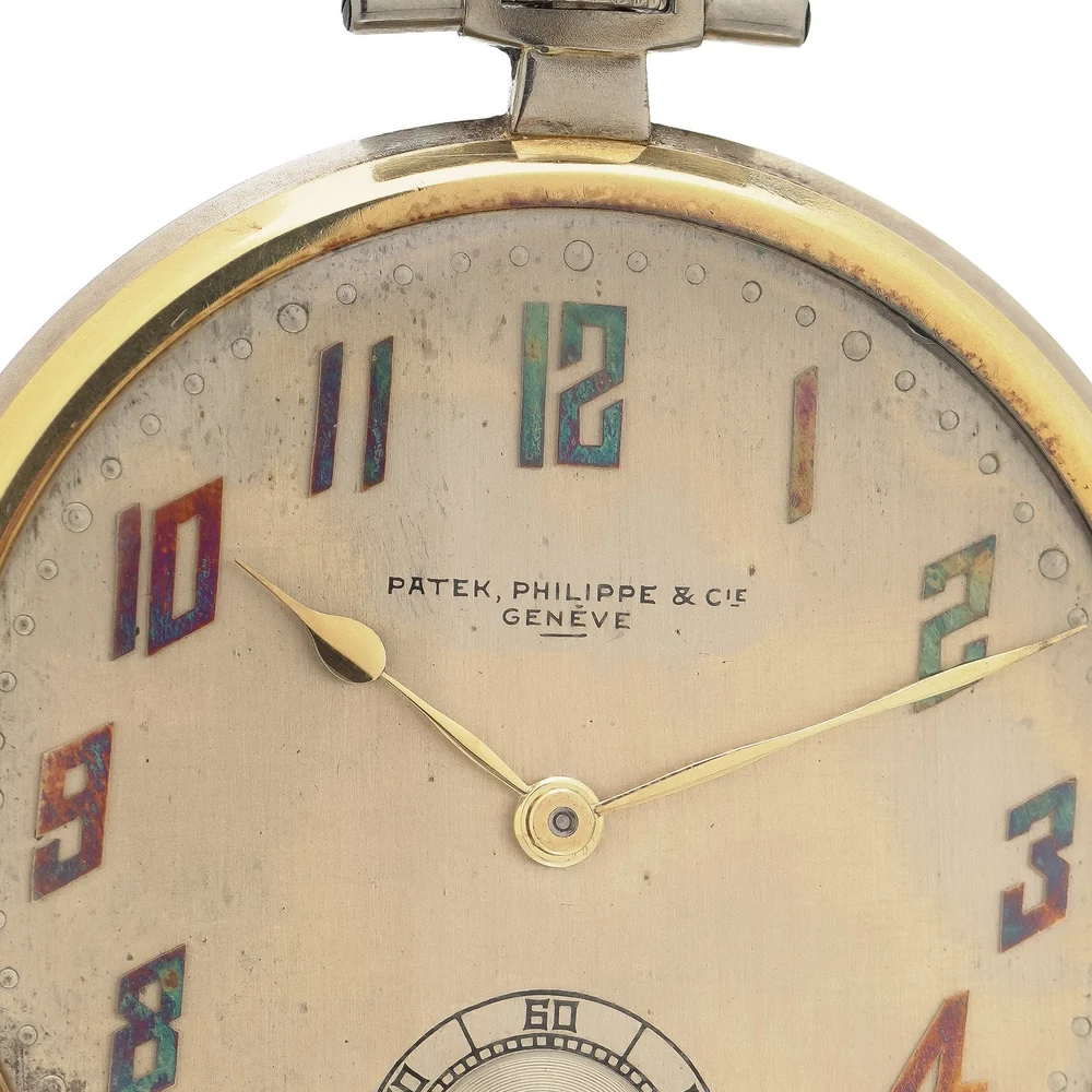 Silvered dial of a 1925 Patek Philippe pocket watch with Arabic numerals filled in red, blue and green enamel