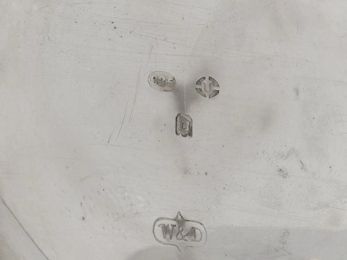 Hallmarks inside the back of a Wilsdorf and Davis silver pocket watch: 925 in an oval, an import town mark, the date letter and the W&D sponsor's mark